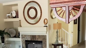 A living room with a fireplace, a sofa, and a dining area with a table and chairs. - Little Paradise in Las Vegas with Pool (Las Vegas)