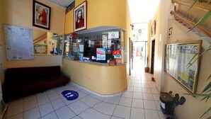 A reception area with a counter, a couch, and a staircase.
