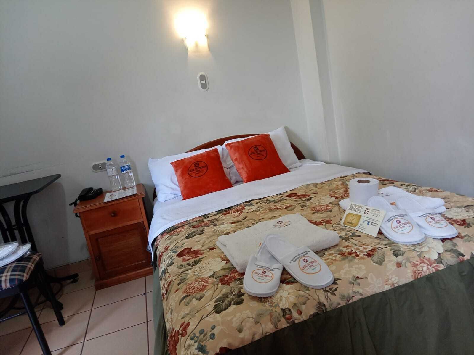 Una habitación de hotel con cama, mesita de noche, silla y mesa.