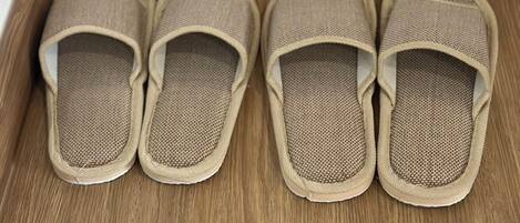 Et par beige slippers på et trægulv.