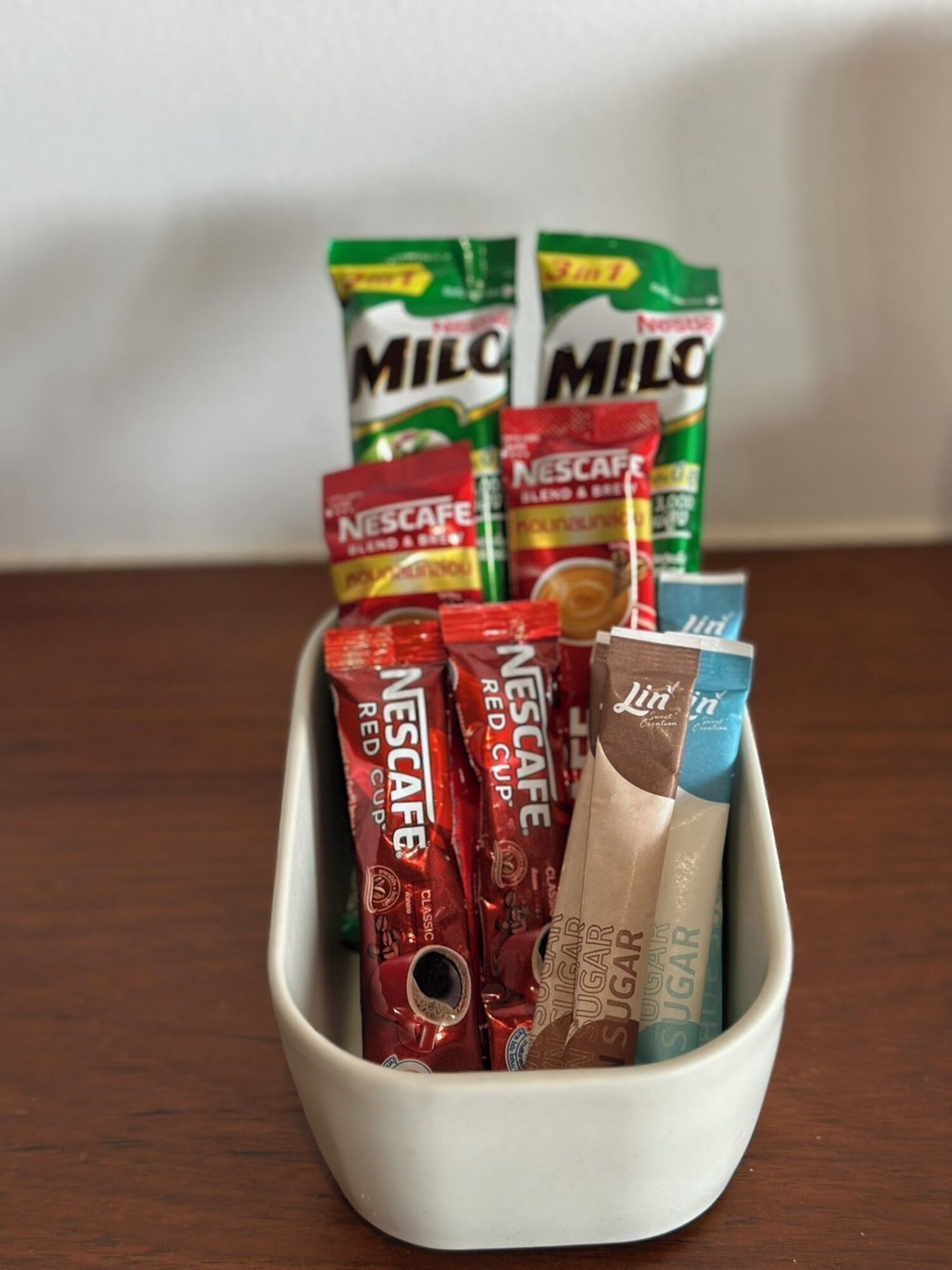 A white container filled with various Nescafe coffee pods.