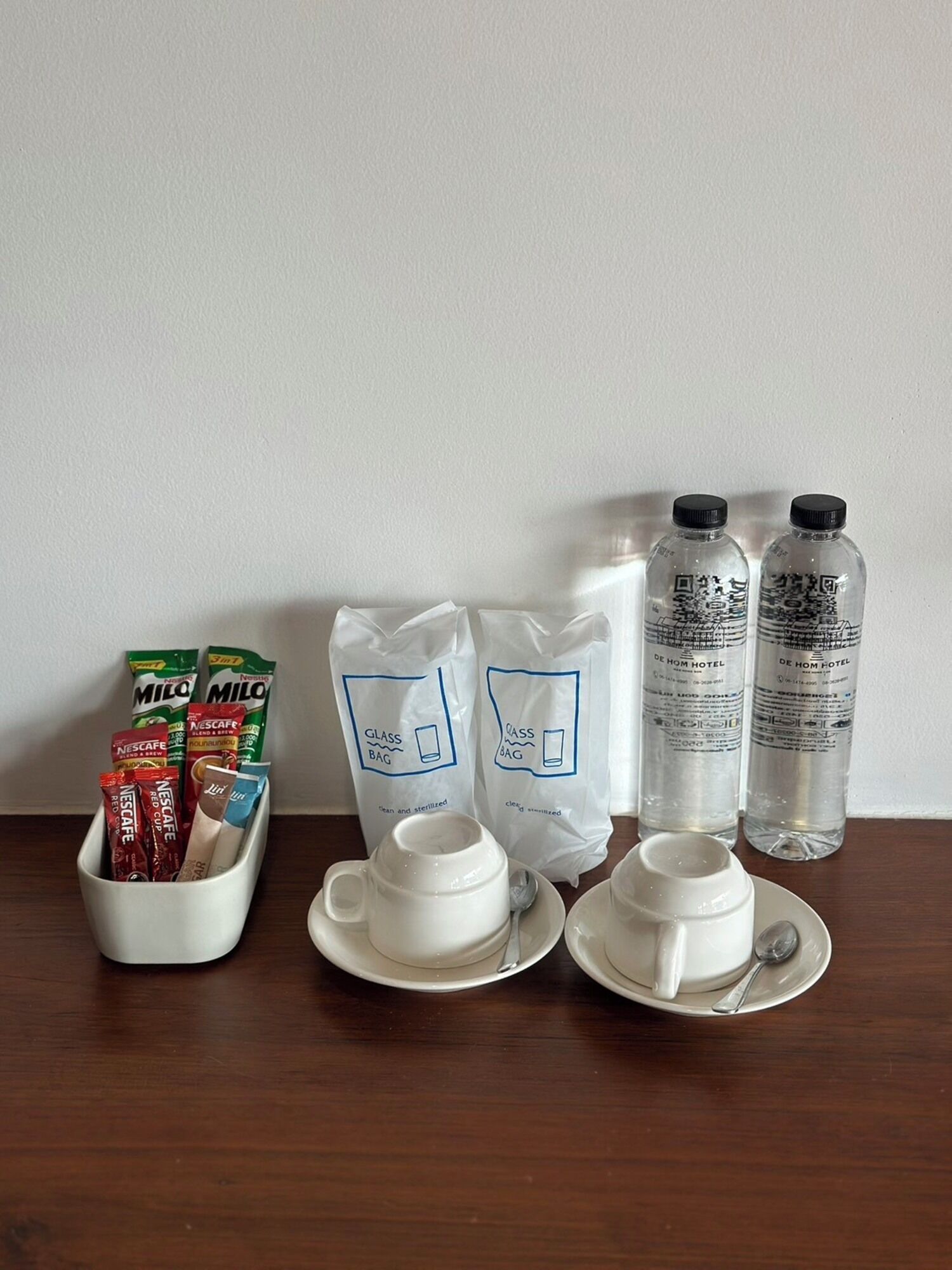 A table with coffee packets, glass bags, and water bottles.