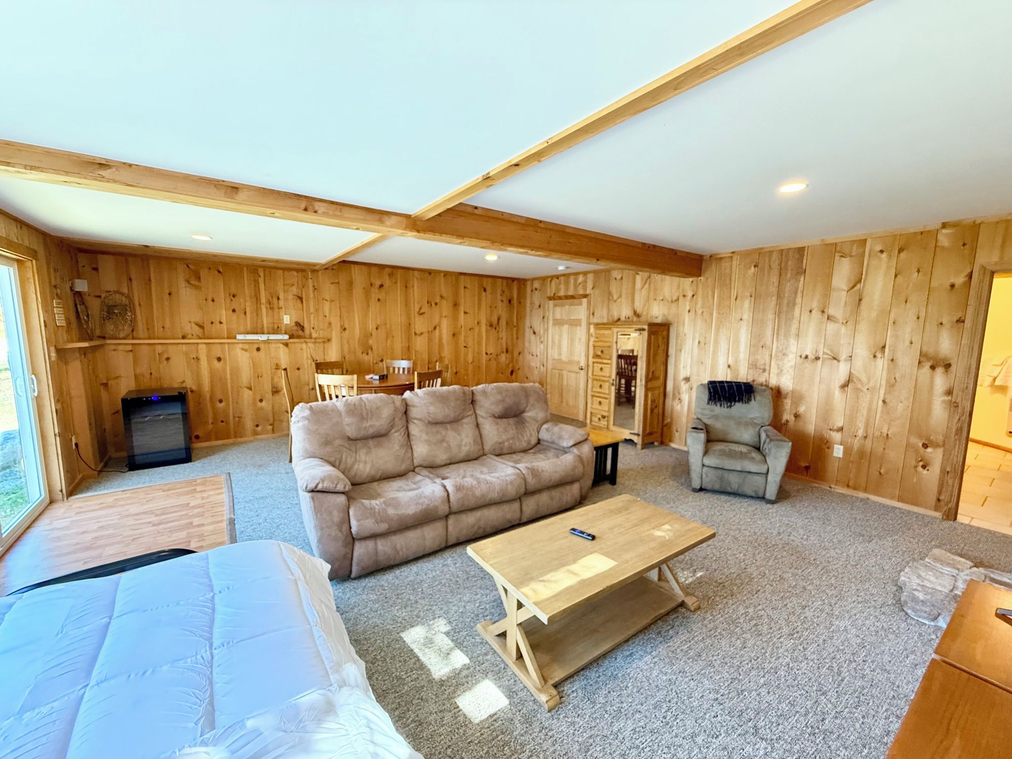 A wooden interior with a sofa, a small table, and a chair.