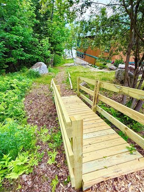 Un pont en bois, situé dans un cadre extérieur luxuriant et verdoyant.