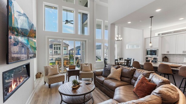 A spacious living room with a large sectional sofa, a fireplace, and a view of the outdoors.