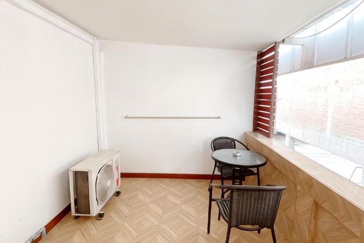 A small room with a fan, a table, and chairs.