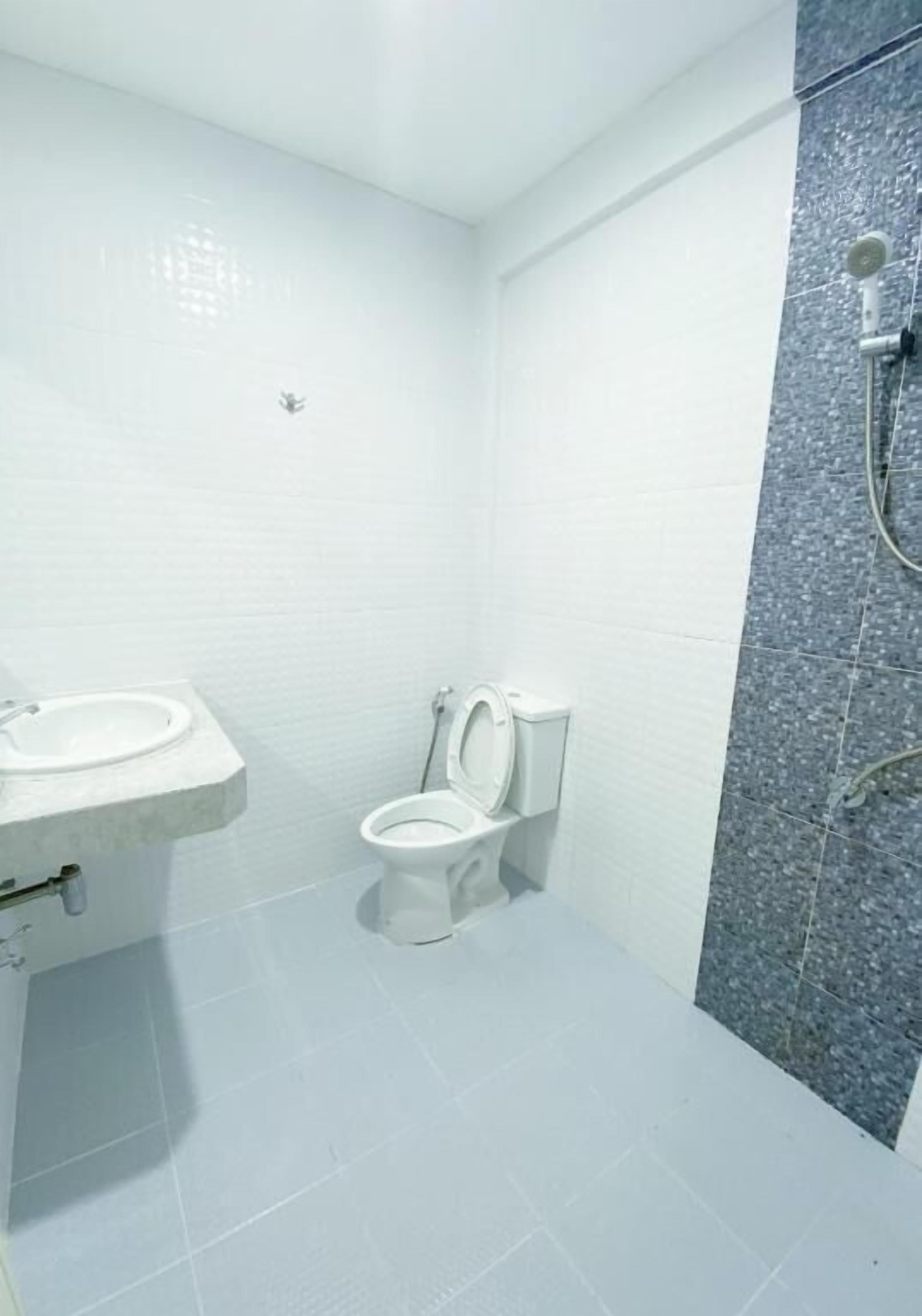 A small, modern bathroom with a toilet, sink, and shower.