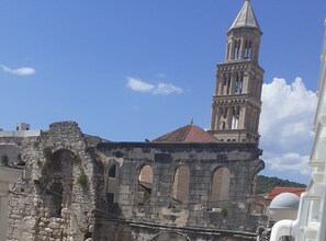 Un antiguo edificio de piedra con un campanario, que presenta ventanas de arco y una fachada desgastada.