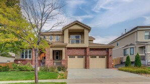A two-story house with a front garage, a small porch, and a well-maintained lawn. - Yard, Home Gym, & Game Room: Spacious Aurora Home (Aurora)