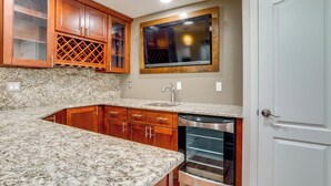 A kitchen with granite countertops, wooden cabinets, a built-in oven, and a window above the sink. - Yard, Home Gym, & Game Room: Spacious Aurora Home (Aurora)