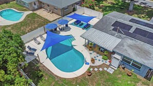 A residential property with two swimming pools, outdoor seating areas, and solar panels on the roof. - Relax Home with Pool and near Beaches in Largo, FL (Largo)