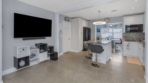 A modern kitchen with white cabinets, a built-in oven, and a large island with bar stools. - Relax Home with Pool and near Beaches in Largo, FL (Largo)