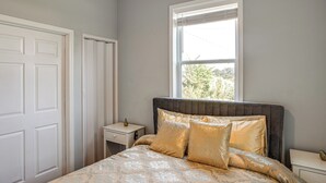 A bedroom with a bed, a nightstand, a window, and a door. - Bring Your Boat! Lake Murray Home w/ Dock & Ramp (Prosperity)