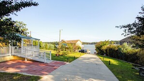A residential street with houses, a covered porch, and a clear view of a lake. - Bring Your Boat! Lake Murray Home w/ Dock & Ramp (Prosperity)