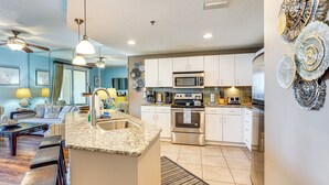 A modern kitchen with white cabinets, stainless steel appliances, and a granite countertop.