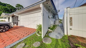 Et moderne hus med garage, en belagt indkørsel og en lille have med brosten.