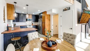 A modern kitchen with dark cabinets, stainless steel appliances, and a wooden island. - 'The High Country Hideaway' Flagstaff Golf Retreat (Flagstaff)