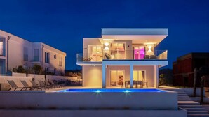 A modern two-story house with a swimming pool, large windows, and a balcony. - Villa Neoma – Tranquil Seaside Escape with Heated Pool and Breathtaking Sea Views (Linardići (Krk))