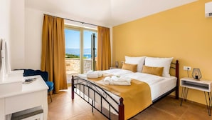 A hotel room with a bed, a desk, a chair, and a view of the sea. - Villa Pinaza B – Romantic Seaside Retreat with Heated Pool, Sauna, and Jacuzzi in Vrbnik (Vrbnik (Krk))