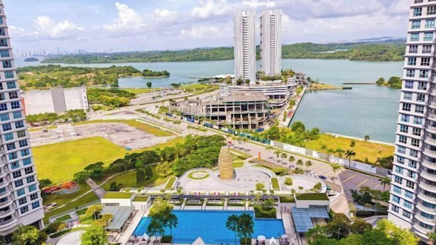 A high-rise building with a swimming pool, surrounded by greenery and a lake. - Teega Suites by RR JBcity (Iskandar Puteri)