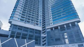 A high-rise building with a modern architectural design, featuring multiple balconies and large windows.