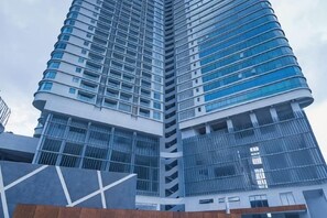 Un immeuble de grande hauteur doté d’une architecture moderne, avec de nombreux balcons et de grandes fenêtres.