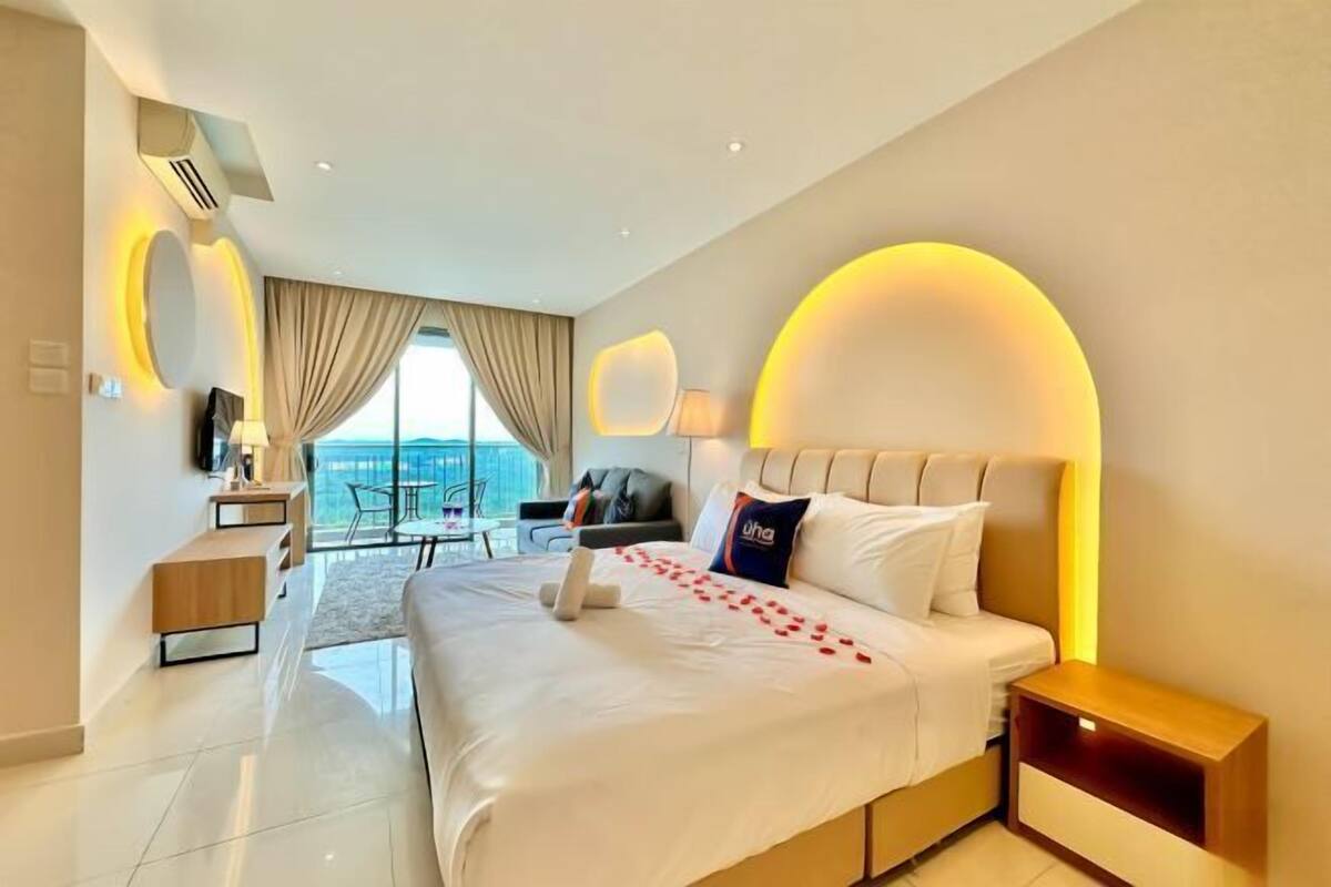 Una camera d'albergo moderna con un letto grande, un comodino, una sedia, una scrivania e vista sull'esterno.