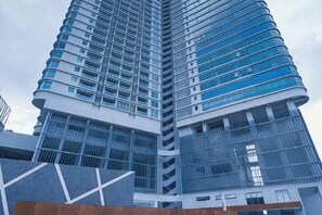 Un edificio alto y moderno con fachada curva y varios balcones.