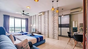 A hotel room with two beds, a balcony, a dining area, and a large window. - Teega Suites by RR JBcity (Iskandar Puteri)