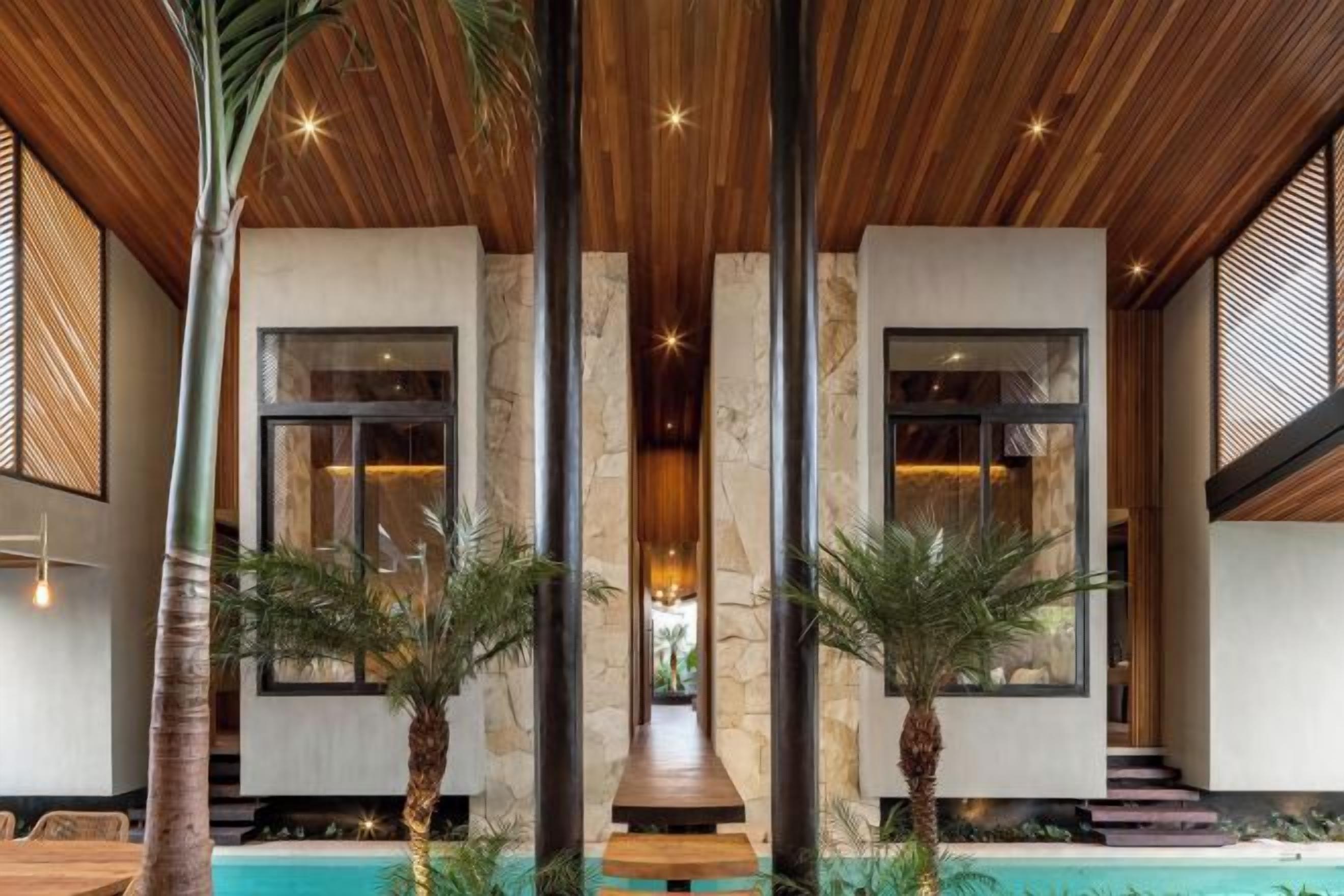A modern interior with a pool, wooden ceiling, and large windows.