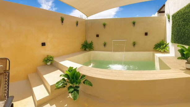 Ein Swimmingpool mit Sonnenschirm, umgeben von Stufen und Topfpflanzen.