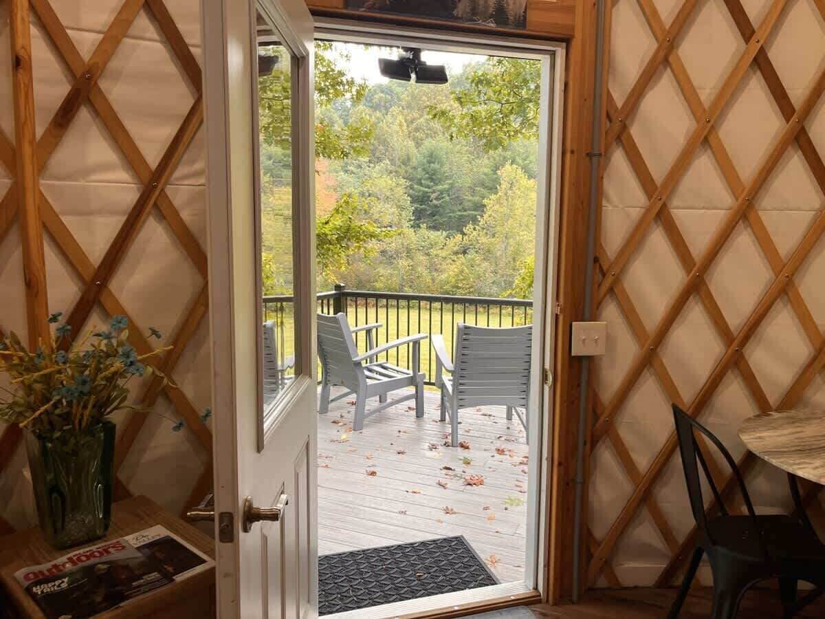A wooden lattice wall, a door leading to an outdoor deck with chairs, and a small table.