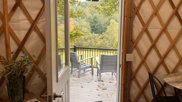 A wooden lattice wall, a door leading to an outdoor deck with chairs, and a small table.