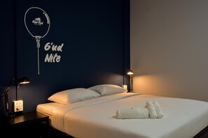 Ein Hotelzimmer mit einem Bett, zwei Nachttischlampen, einem Nachttisch und einer Wanddekoration.