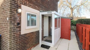 Una casa de ladrillo con una puerta blanca y una ventana con persianas.