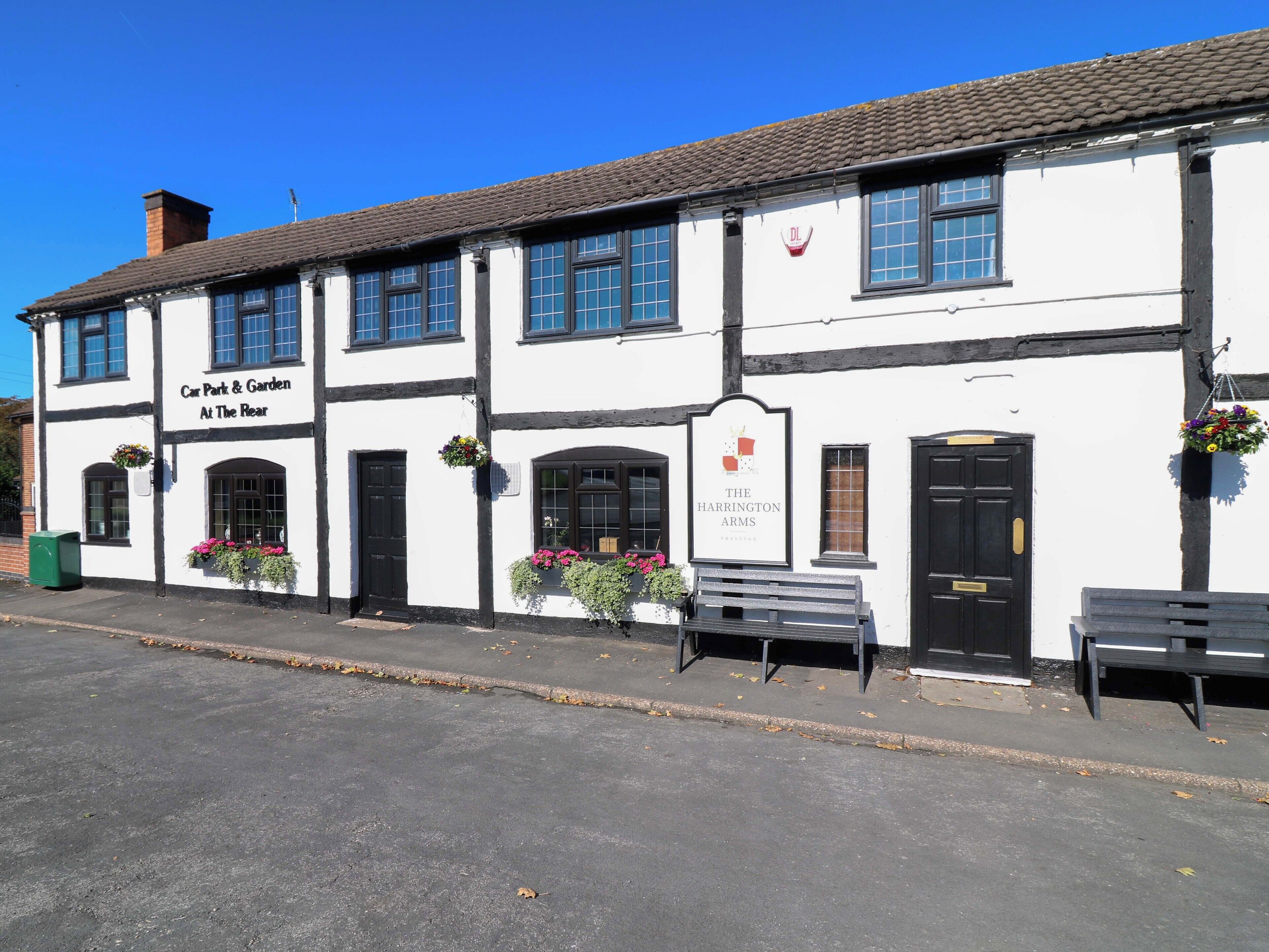 A traditional building with a sign 'Car Park & Garden At The Rear' and 'The Harrington Arms' indicating a pub.