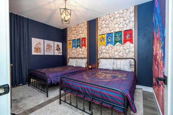 Una habitación con dos camas, una pared de piedra y varias banderas.