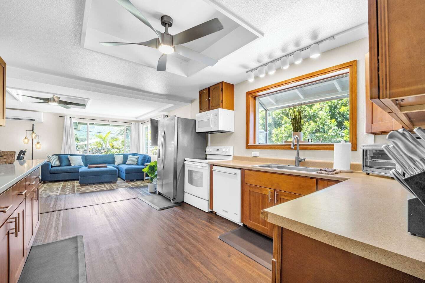 A modern kitchen with a large window, a built-in oven, and a refrigerator.