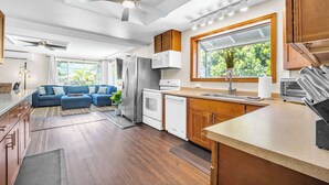 A modern kitchen with a large window, a built-in oven, and a refrigerator.