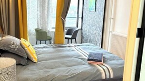 Une chambre d’hôtel avec un lit, une chaise et une vue sur la ville.