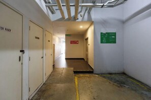 A narrow hallway with a ramp leading to a door labeled 'EXIT RISE.'