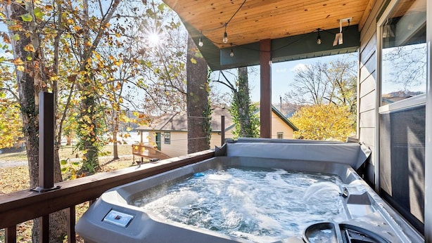 A hot tub with a wooden deck and a view of a park with autumn trees. - Wren Cabin - Private Hot Tub, Fireplace, and Lake View (Forsyth)