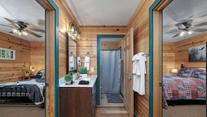 A wooden cabin with a bathroom, a bedroom, and a dining area. - Wren Cabin - Private Hot Tub, Fireplace, and Lake View (Forsyth)