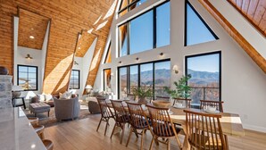 A spacious loft with high ceilings, large windows, and a dining area with wooden chairs.