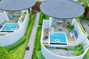 Una vila moderna amb dues piscines circulars, un porxo cobert i un jardí ben cuidat.