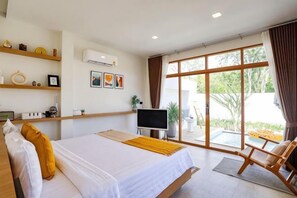 Habitación de hotel con cama, televisión, escritorio y un amplio ventanal.
