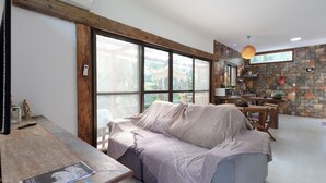 Una sala de estar moderna con un ventanal grande, una mesa de madera y una pared de piedra.