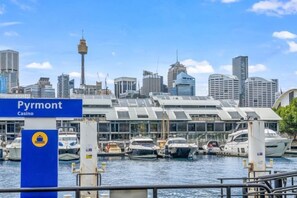 A marina with boats, a casino sign, and a city skyline in the background. - Luxe Living Terrace by The Star - Luxury in Sydney (Pyrmont)