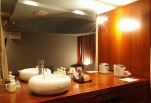 A hotel bathroom with two sinks, a mirror, and a vanity with toiletries. - Blue Hotel Nagi-Adult Only (Otaru)
