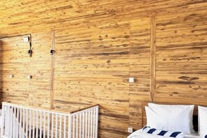 Un intérieur en bois avec un berceau et un lit.